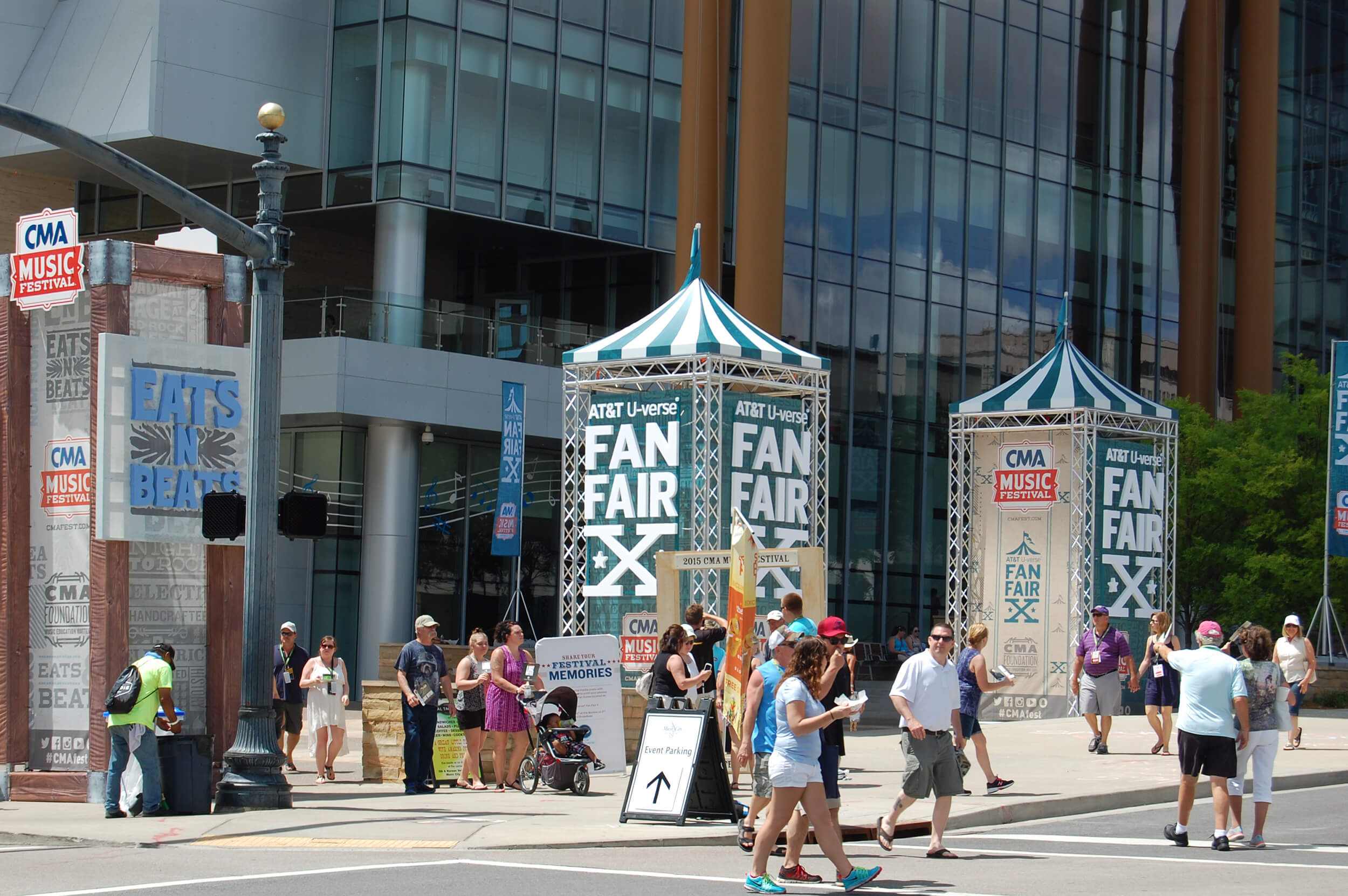 People walking in front of CMA Fest Fan Fair X and Eants N Beats signage in Nashville