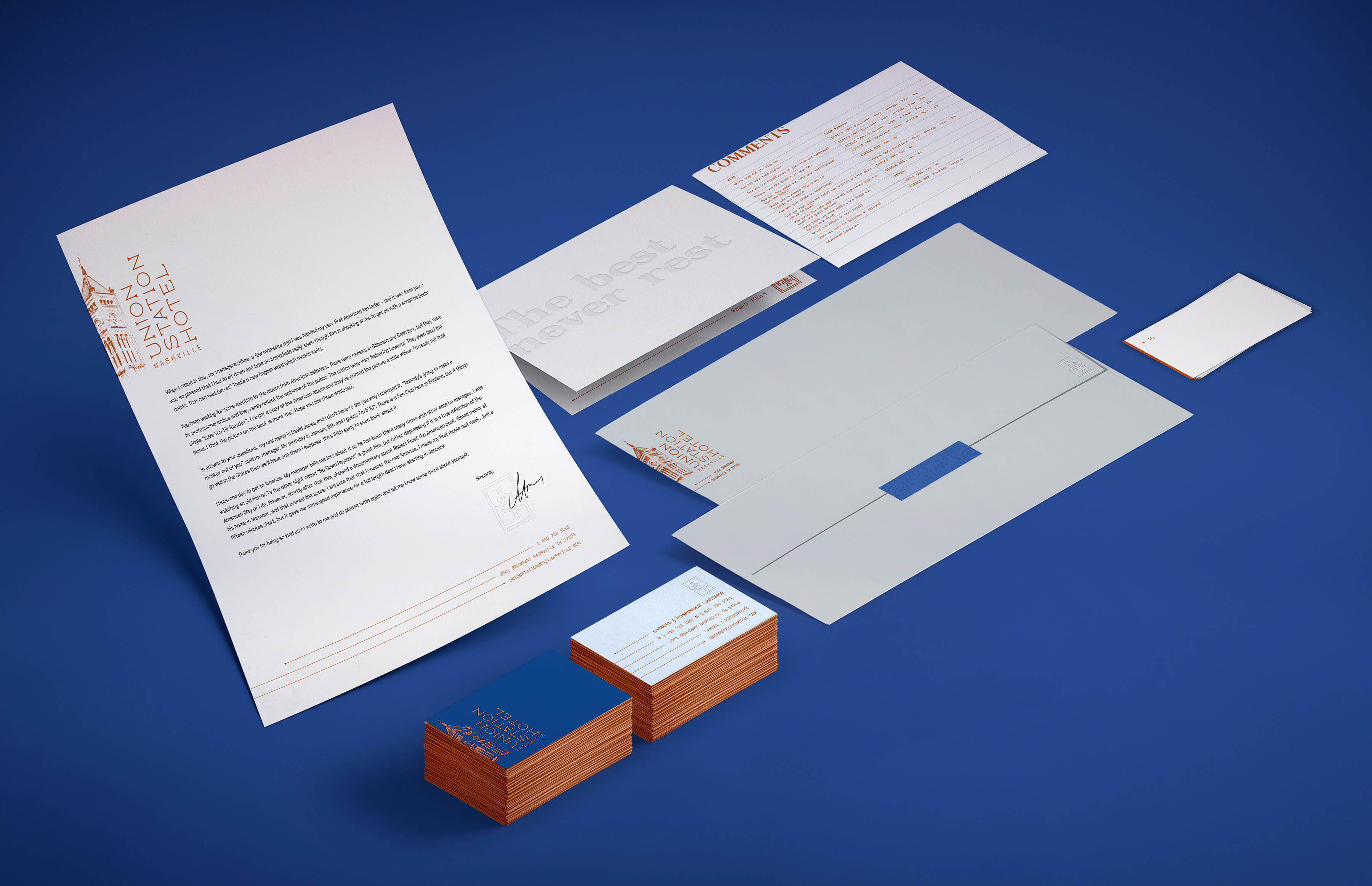 Example of custom letterhead, comments card, business cards, envelopes and note card on blue.
