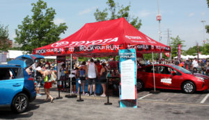Toyota Rock Your Run. Photo of the Toyota Rock Your Run cheer station and a 2x7 TFE sign.