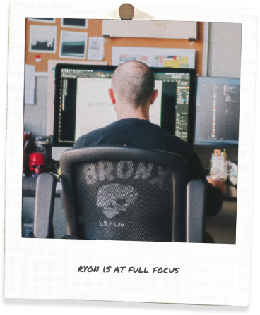 polaroid of ryon at his desk with caption, ryon is at full focus