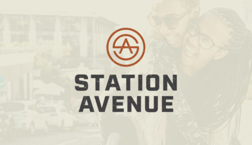 Station Avenue vertical logo in rust color with charcoal type on faded background image of two girls smiling