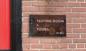 OZ Tyler wayfinding weathered metal sign with oak barrel imagery that says Tasting Room and Tours