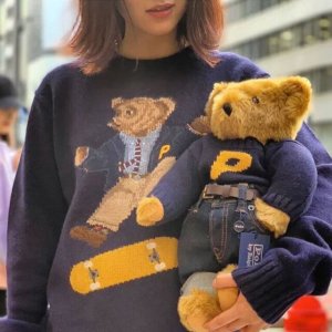 woman wearing sweater and holding a teddy bear from Palace and Ralph Lauren 2018 fashion collaboration