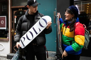 Man and woman holding POLO branded skateboard from Palace x Ralph Lauren collaboration