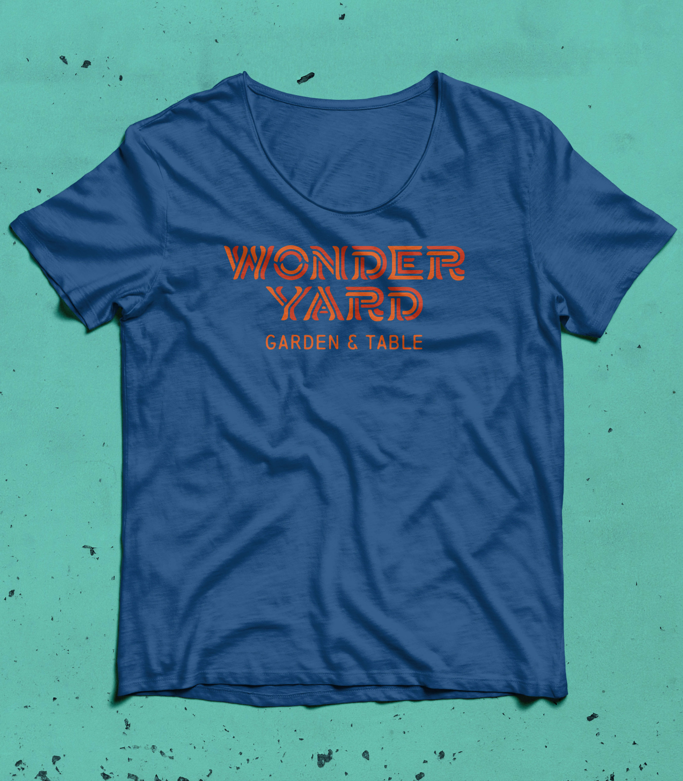 wonderyard restaurant branded shirt on teal background