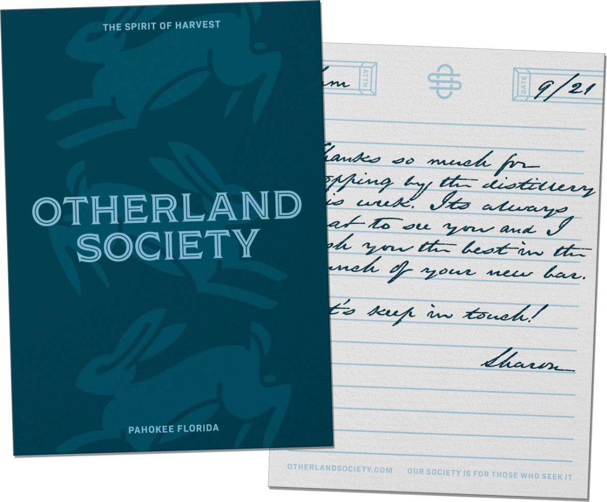 Otherland Society notecard with front and back design, on front it reads "The spirit of harvest, Otherland Society (logo), Pahokee Florida." with the hare mascot graphic in background. The back is lined and includes additional design elements, on the bottom it reads "otherlandsociety.com, Our society is for those who seek it."