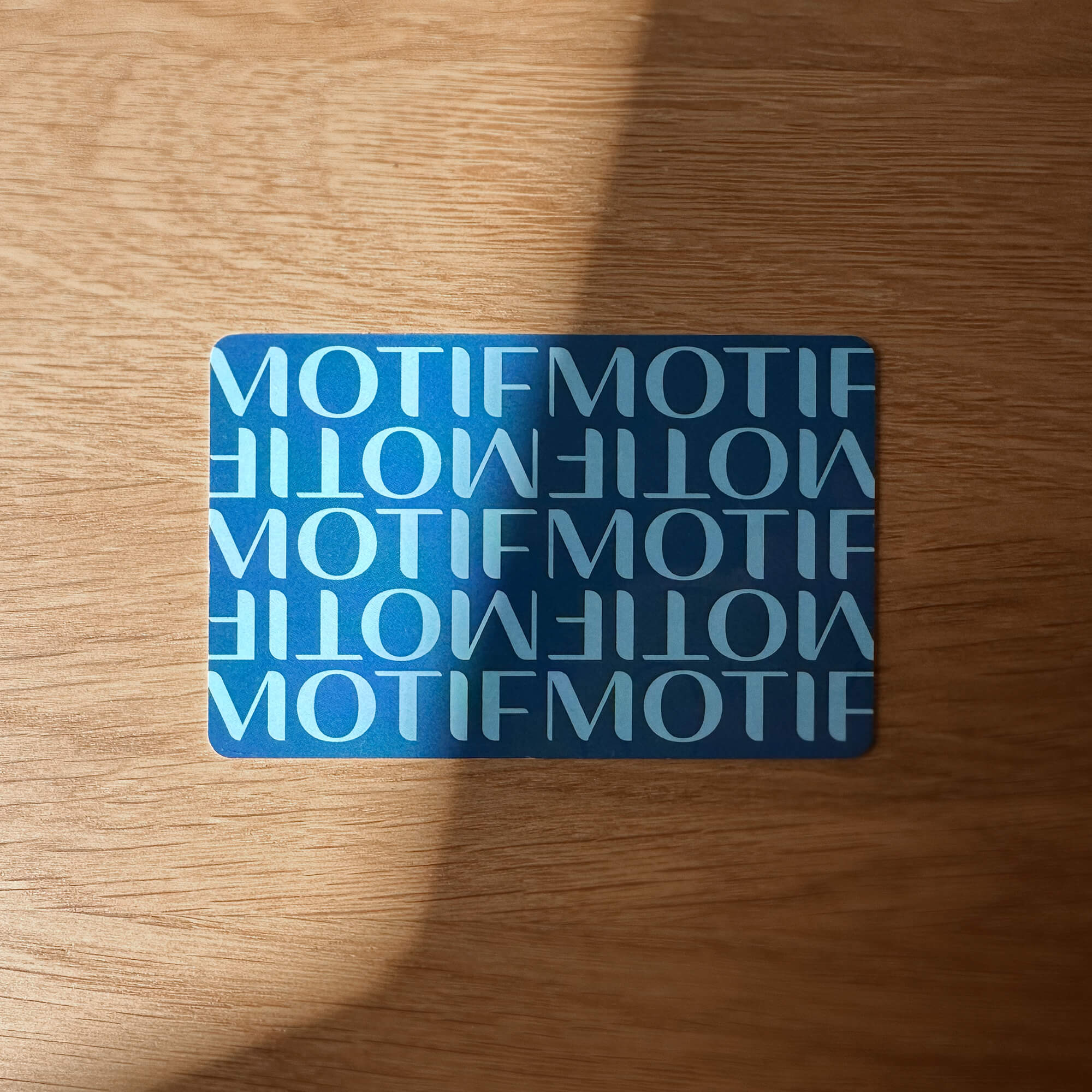 Custom logotype pattern design on boutique hotel keycard on wood background