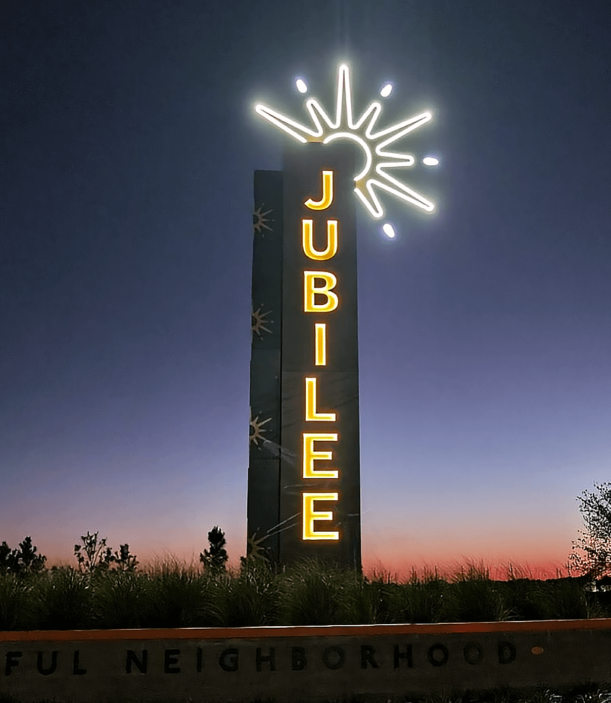 Jubilee entry monument signage lit up at night for master-planned community in Texas designed by ST8MNT