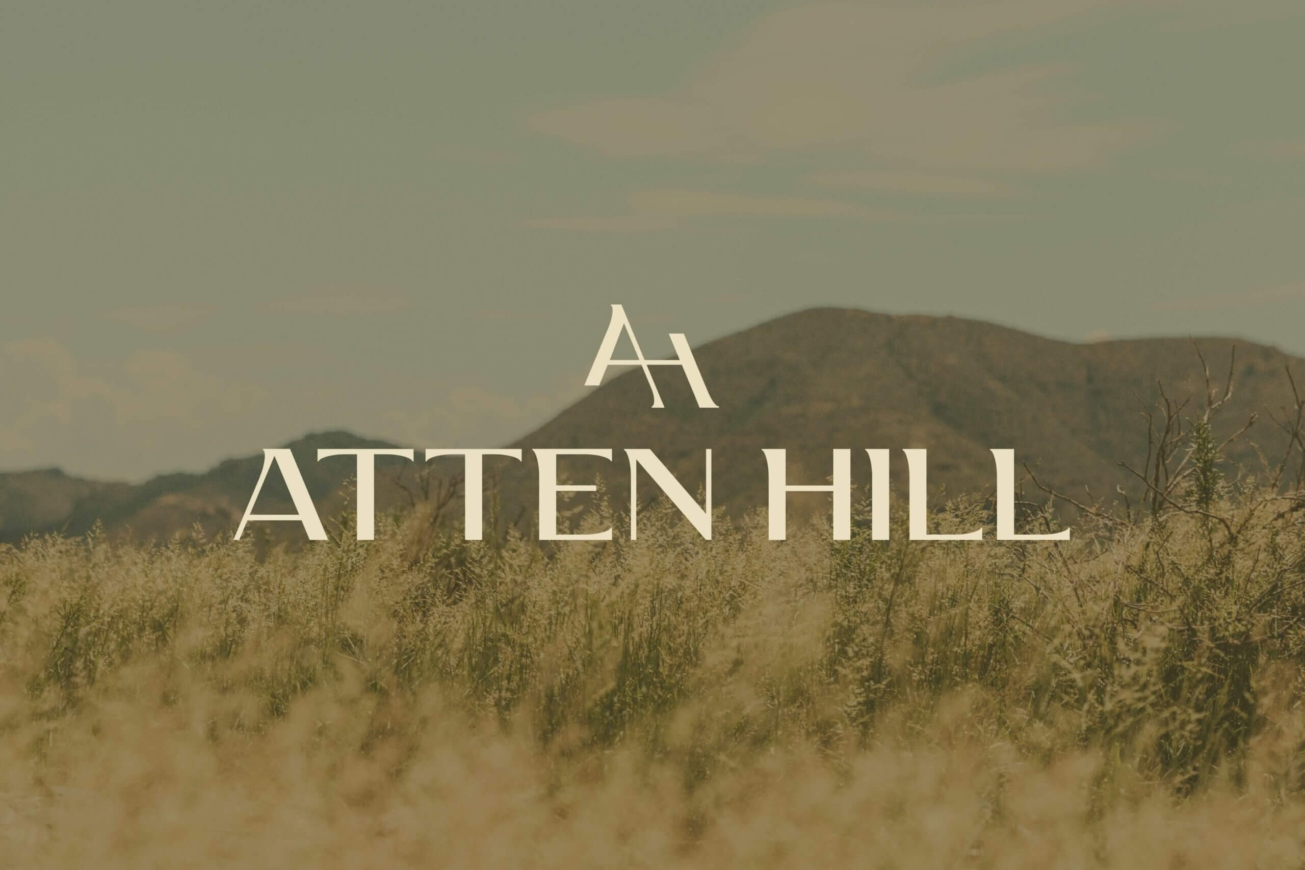 Atten Hill logo designed by St8mnt place over top of an image of the Texas hill country.