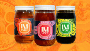 Product packaging design for IM Sweet, IM Spicy and IM Wok sauces on an orange background for International Market in Nashville, TN
